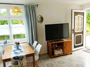a living room with a table and a television at Rosenhof Ferienwohnungen in Mölln-Medow