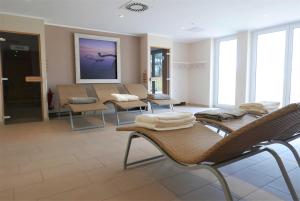 a waiting room with chairs and tables and windows at Haus Meeresblick - Ferienwohnung Ostseeperle A 0.13 (Ref. 128670) in Baabe
