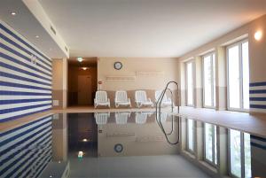 a swimming pool with chairs and clocks on the wall at Haus Meeresblick - Ferienwohnung Kreideküste (Ref. 151261) in Baabe +20 photos