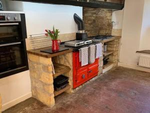 a kitchen with a stone counter with a red stove at 6 Bedroom Farm House with 12 Beds in Weldon in Weldon