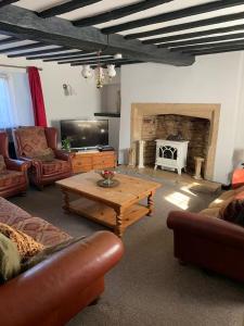 a living room with couches and a table and a fireplace at 6 Bedroom Farm House with 12 Beds in Weldon in Weldon +43 photos