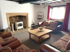 a living room with a table and a fireplace at 6 Bedroom Farm House with 12 Beds in Weldon in Weldon