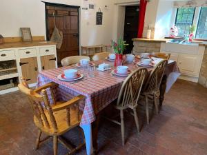 a dining room table with chairs and a tablecloth on it at 6 Bedroom Farm House with 12 Beds in Weldon in Weldon