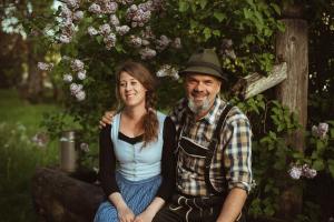 a man and a woman sitting on a log at Primushäusl Gästehaus in Strobl