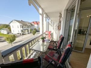 a balcony with chairs and a table and a view of a street at Villa Annika - Whg 06 in Ostseebad Sellin