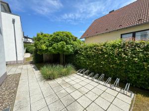 a row of chairs sitting on a sidewalk next to a hedge at Villa Annika - Whg 06 in Ostseebad Sellin