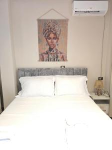 a bedroom with a bed with a painting above it at Hotel Natali 2 in Dhërmi