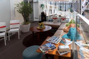a room with a couch and tables and chairs at House Barra Beach in Praia da Barra