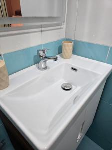a white sink in a bathroom with a mirror at Hotel Natali 2 in Dhërmi +20 photos