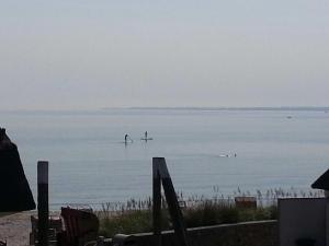 two people are paddle boarding on the water at Strandhaus Buchtmitte in Haffkrug