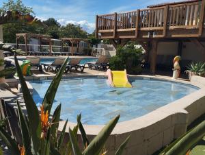 a swimming pool with a yellow chair and a deck at Camping les Acacias in Fréjus