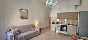 a living room with a couch and a kitchen at Casa Nicole - Letojanni Taormina in Letojanni