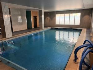 a large indoor swimming pool with blue water at DOMITYS - L'Edito in Amiens