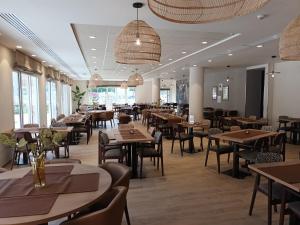 a restaurant with tables and chairs and windows at DOMITYS - L'Edito in Amiens