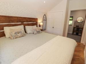 a bedroom with a large white bed with pillows at Cân yr adar in Bridgend