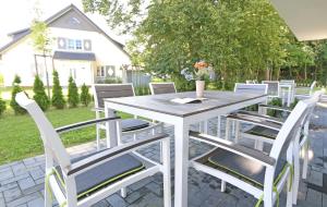 a white table and chairs on a patio at Haus Sonne - Whg 01 Sandperle in Thiessow