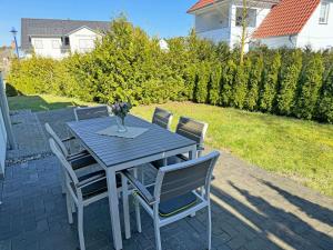 a table with chairs and a vase of flowers on a patio at Haus Sonne - Whg 01 Sandperle in Thiessow +19 photos
