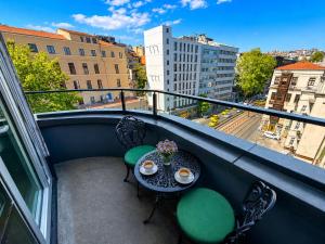 a table and chairs on a balcony with a view of a city at The Tram Karakoy in Istanbul
