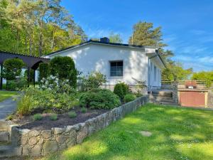 a white house with a stone retaining wall at Ferienhaus Hete in Staphel