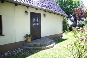 a house with a door and some flowers at Ferienwohnungen im Altbauernhaus in Hohendorf +16 photos