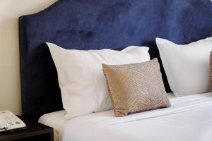a bed with white pillows and a blue headboard at hôtel LE PACHA in Tunis +36 photos