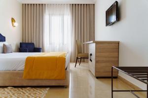 a hotel room with a bed and a television at hôtel LE PACHA in Tunis