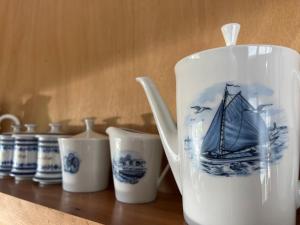 a teapot sitting on a table with other cups at Over Lake in Monnickendam