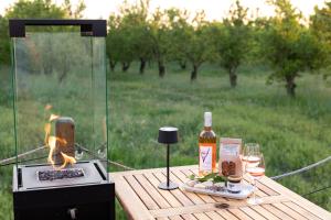 a picnic table with a grill and a bottle of wine at La bulle ico in Valensole