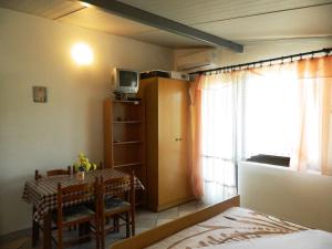 a room with a dining room table and a window at Apartment Jakoubek in Rogoznica