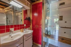 a bathroom with a sink and a red door at La Barraço in Nalzen