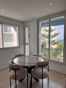 a dining room with a glass table and two chairs at Perle Bleue de Gammarth in Gammarth