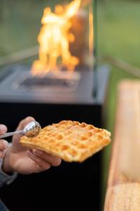 a person holding a plate of waffles with a spoon at La bulle ico in Valensole