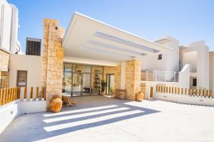 a contemporary house with white walls and ceilings at Ramnus Karpathos Suites in Karpathos