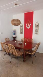 a dining room table with chairs and a red wall at La Case Creole in Roches Noires +21 photos