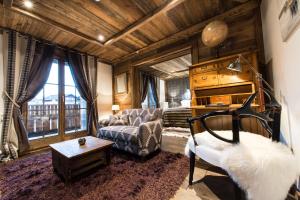 a living room with a couch and a table at Le Chalet Blanc in Megève