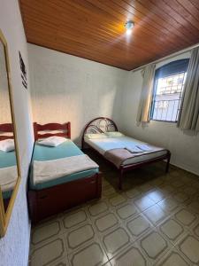 a room with two beds and a window at Pousada famíliar no Centro com café da manhã incluso in São Lourenço