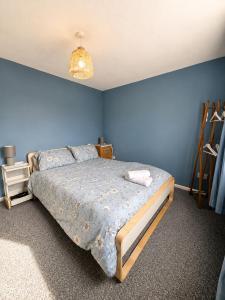 a bedroom with a bed with a blue wall at Double Room Near Cardiff Bay Waterfront in Cardiff