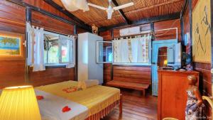 a bedroom with a bed and a table in a room at Villa Razambe in Mandriankeniheny