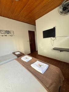 a bedroom with a bed with a flat screen tv on the wall at Pousada famíliar no Centro com café da manhã incluso in São Lourenço