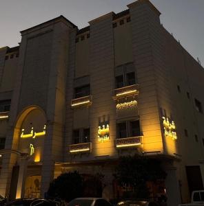 a building with yellow lights on the side of it at شقق الشرفة للشقق المفروشة -AlSHORFA FURNISHED APARTMENT in Riyadh