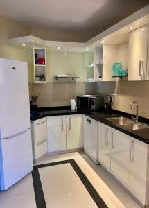 a kitchen with white cabinets and a white refrigerator at Caracara D1 Relax & Dive Resort Bonaire Village in Kralendijk +13 photos