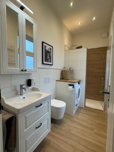 a bathroom with a sink and a washing machine at Villa Manninga in Krummhörn +10 photos