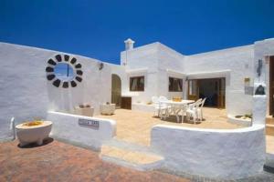 a white house with a patio and a table at Villa Ann Lanzarote in Nazaret