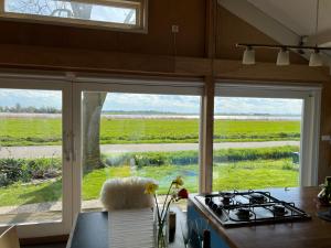 a kitchen with a view of a field through windows at Over Lake in Monnickendam