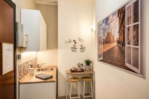 a small kitchen with a sink and two stools at Casa Giulia Affittacamere FORUM ASSAGO M2 M1 Milano CENTRO in Corsico