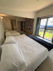 a large white bed in a room with a window at Casa en Cuernavaca Morelos in Cuernavaca +18 photos