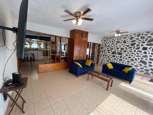 a living room with a blue couch and a ceiling fan at Casa en Cuernavaca Morelos in Cuernavaca