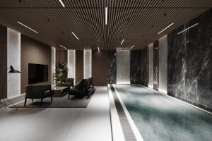 a swimming pool in a lobby with chairs and a television at Lake Charvak Resort in Burchmulla