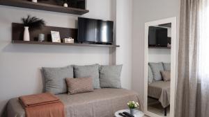 a living room with a couch and a mirror at Casa Linda Affitacamere Rozzano HUMANITAS FORUM ASSAGO M2 MILANO Centro IEO in Rozzano
