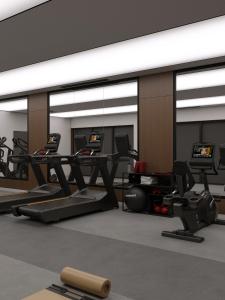 a gym with treadmills and ellipticals in a room at Lake Charvak Resort in Burchmulla
